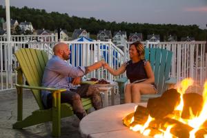 un homme et une femme assis autour d'un feu sur un pont dans l'établissement Stormy Point Village, à Branson