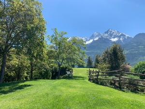 una valla en un campo con montañas en el fondo en Hotel Milleluci, en Aosta