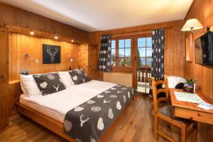 1 dormitorio con 1 cama y escritorio con escritorio en Petit Paradis, en Crans-Montana