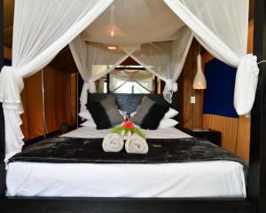 um quarto com uma cama branca e 2 almofadas em Turtle Bay Lodge em Luganville