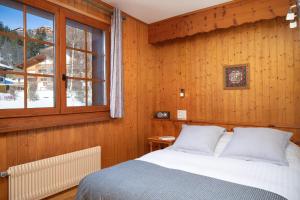 1 dormitorio con cama y ventana en Petit Paradis, en Crans-Montana