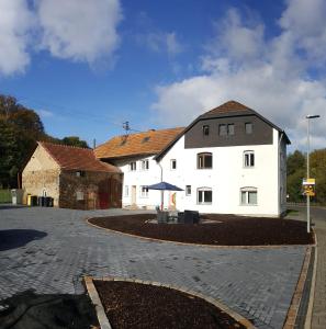 un gran edificio blanco con un patio delante de él en The Ring Inn, en Adenau