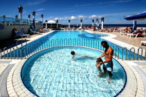 Ein Mann und ein Kind im Schwimmbad. in der Unterkunft Hotel Gran Vista Plava Laguna in Poreč