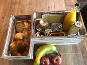 een lunchbox met appels en bananen en ander voedsel bij Veldzicht Metslawier in Metslawier