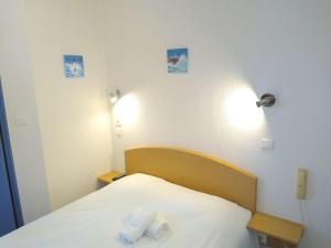 a bedroom with a bed with two towels on it at Hôtel des Sables Blancs in Douarnenez