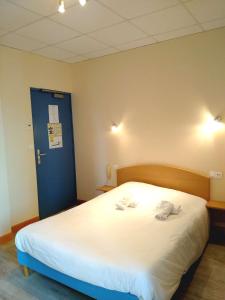 a bedroom with a large bed with two towels on it at Hôtel des Sables Blancs in Douarnenez