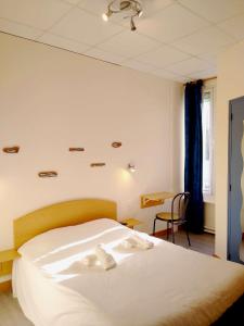 a bedroom with a bed with white towels on it at Hôtel des Sables Blancs in Douarnenez