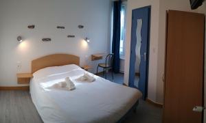 a bedroom with a bed with two towels on it at Hôtel des Sables Blancs in Douarnenez