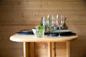 een tafel met drie wijnglazen en borden erop bij KampinaStaete, hippe cottages midden in natuurgebied de Kampina Oisterwijk in Oisterwijk