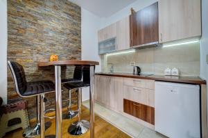 a kitchen with wooden cabinets and a bar in it at Vila Pekovic, Pine Trees View Apartment with big balcony in The Center of Zlatibor! in Zlatibor