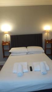 a large white bed with three towels on it at Penny Farthing Hotel & Cottages in Lyndhurst