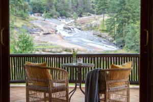 a table and two chairs on a balcony with a view at Silverstone Lodge in Mbabane