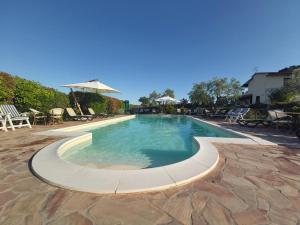 ein großer Pool mit Stühlen und einem Sonnenschirm in der Unterkunft Agriturismo - B&B L'Acquacotta in Castiglione della Pescaia