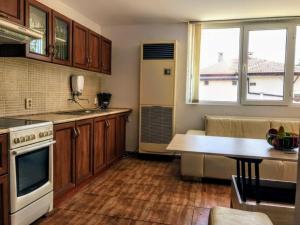 una cocina con armarios de madera y una mesa. en Villa Bianca, en Balchik