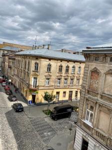 een oud gebouw met auto's voor het gebouw bij Opera Center Hotel & Apartments in Lviv