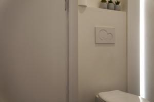 uma casa de banho branca com um WC e um interruptor de luz em Well-situated and Comfortable Home em Gante