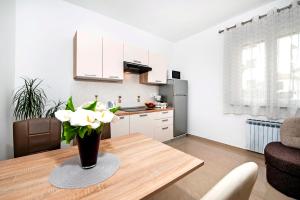 uma cozinha com uma mesa com um vaso de flores em Apartments Euphemia em Rovinj