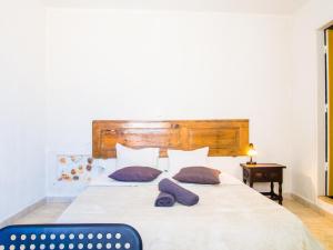 una camera da letto con un grande letto bianco con due cuscini viola di RIA Terrace a Faro