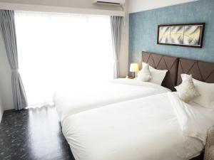 A bed or beds in a room at Beach Front Tower Mihama by DSH