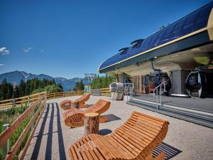 una fila di panche di legno presso una stazione ferroviaria di Olympiahaus a Garmisch-Partenkirchen