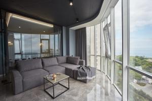 - un salon avec un canapé et de grandes fenêtres dans l'établissement Gagarin Plaza Luxury Sea View Apartments, à Odessa