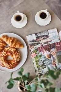 une table avec une assiette de pain et deux tasses de café dans l'établissement Gagarin Plaza Luxury Sea View Apartments, à Odessa