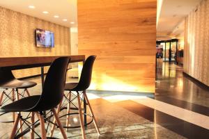 una hall con bar con sedie nere e pareti in legno di Best Western Mirage Hotel Fiera a Paderno Dugnano