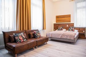 a living room with a couch and a bed at City Hotel Bamberg in Bamberg