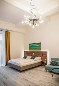 a bedroom with a bed and a chandelier at City Hotel Bamberg in Bamberg