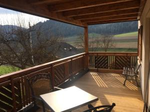 een veranda met een tafel en stoelen op een balkon bij Appartements Wiesenheim in Rasun di Sopra