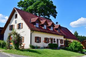 Biały dom z czerwonym dachem w obiekcie Ferienwohnung Burgerhof w mieście Pullenreuth