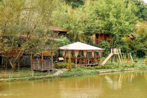 una casa con parco giochi accanto a un fiume di Bilya Richky Hotel a Kam"janec'-Podil's'kyj