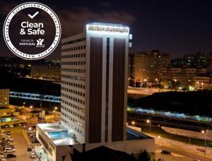 um edifício alto e branco com uma placa em cima em VIP Executive Zurique Hotel em Lisboa