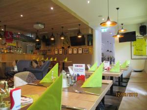 un restaurant avec des tables en bois et du papier vert sur elles dans l'établissement Aparthotel Garni Schranz, à Wald im Pinzgau