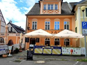 un edificio con due ombrelloni davanti di Penzion - Restaurant U Zámku a Bečov nad Teplou