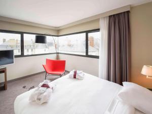 Un pat sau paturi într-o cameră la Mercure Cholet Centre