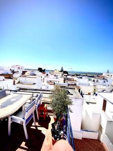 uma varanda com cadeiras e uma moto num edifício em Zenit Olhao Bed & Breakfast em Olhão