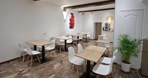 a room with wooden tables and white chairs in a room at Hôtel Le Chambellan in Dijon