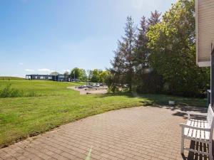 a park with a bench and a building in the background at Holiday Home Sandskærvej II in Aabenraa