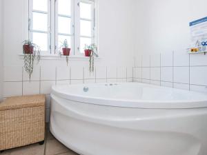 a white bath tub in a bathroom with windows at Holiday Home Sandskærvej II in Aabenraa