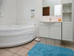 a white bathroom with a tub and a sink at Holiday Home Sandskærvej II in Aabenraa