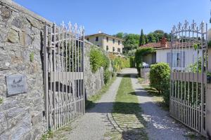 un ingresso a un muro di pietra con cancello di ferro di Villa Maona - con piscina tra Firenze e Pisa a Montecatini Terme