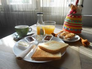 een tafel met een bord toast en een kop jus d'orange bij Hostal El Callejón in Tarragona