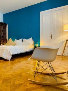 um quarto azul com uma cama e uma cadeira em Crops City Stay em Trieste