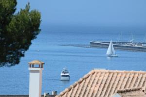 deux bateaux dans une masse d'eau avec phare dans l'établissement Cascais Estoril Apartment 400 m from Beach, à Estoril