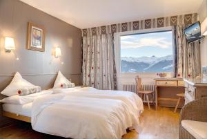 een hotelkamer met een bed en een groot raam bij Hotel Ad'Eldorado in Crans-Montana