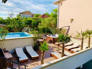 einen Balkon mit Pool und eine Terrasse mit Palmen in der Unterkunft Apartments Tati in Ulcinj