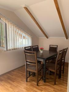 a dining room with a black table and chairs at Guest House IBERIA in Mtskheta