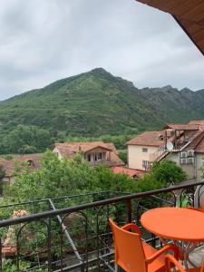 a balcony with a table and chairs and a mountain at Guest House IBERIA in Mtskheta