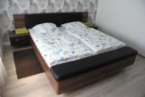 łóżko z czarną ramą i białą pościelą w obiekcie Geräumige 4 Zimmer Wohnung an den Kaiserthermen w Trewirze